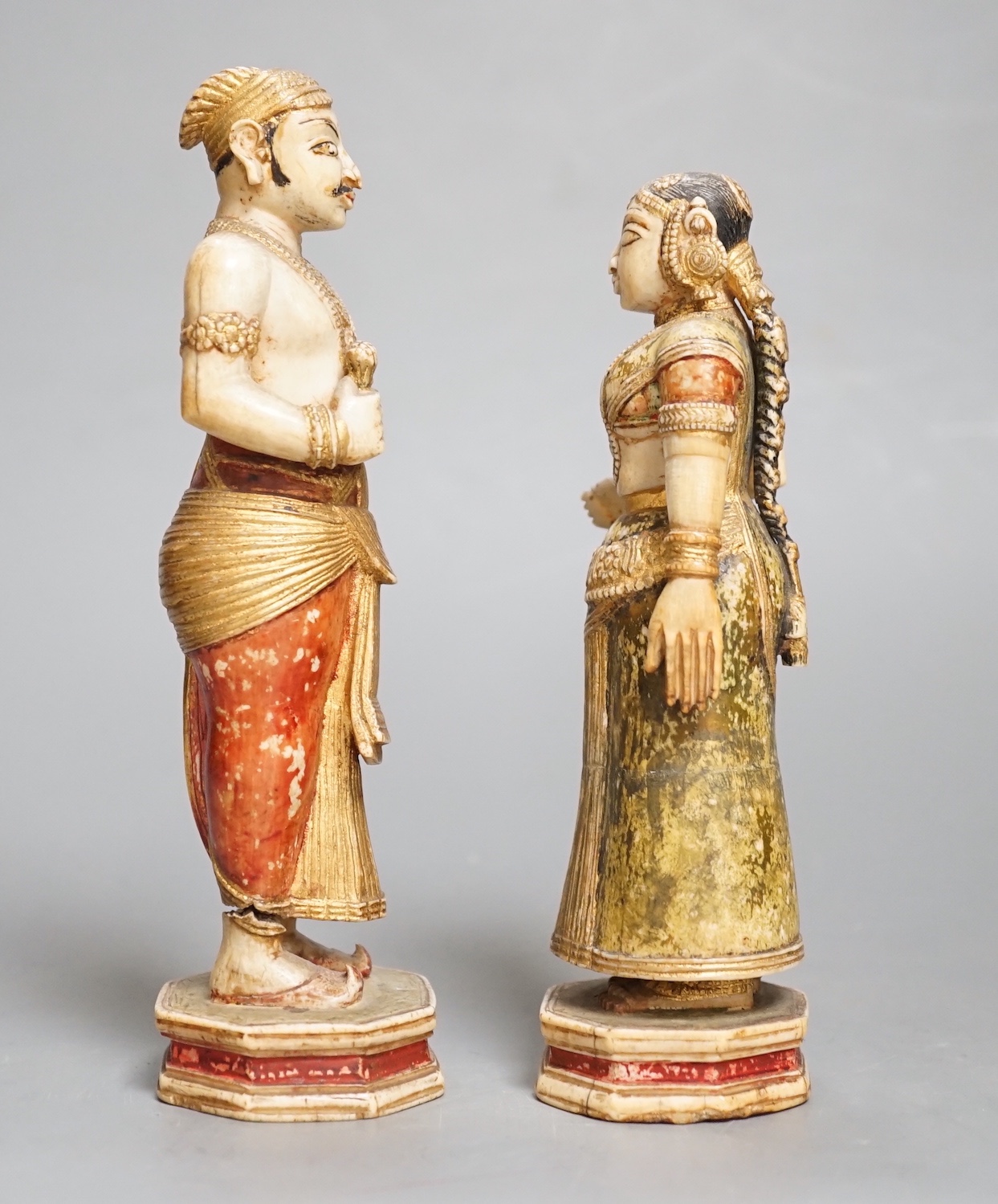A pair of 18th century painted carved Indian ivory figures, male 7.6cm high female: 5.5cm high